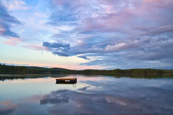 Swimming island in Sweden on a lake at sunset. Clouds reflected in the water. Swimming fun on vacation with recreation in Scandinavia