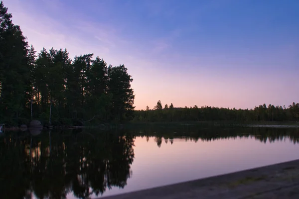 Sunset on a lake in Sweden. Blue hour on calm water. Nature photo from Scandinavia. Landscape shot