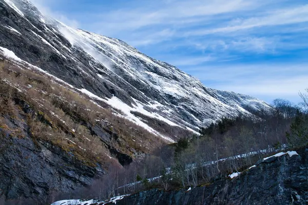 Norveç manzarası. Yol, buzuldan inen bir dağ geçidine çıkıyor. İskandinavya 'nın kaba doğası. Kuzeyden manzara fotoğrafı.