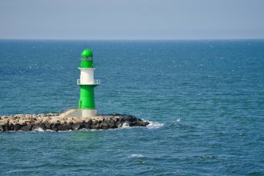 Baltık Denizi 'ndeki yeşil ve beyaz deniz feneri. Taşın kenarındaki dalgalar. Nakliye için harika bir sinyal. Almanya 'dan manzara fotoğrafı