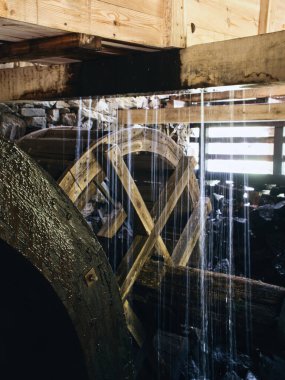 Eski ahşap su çarkı dökülen suyla sulanır. İsveç 'teki bir su değirmeninden fotoğraf..