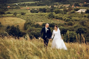 Gelin ve damat el ele tutuşur ve doğanın ortasında geleceğe bakar. Yeni evliler birlikte yürür. Düğün fotoğrafçılığı, ölüm bizi ayırana kadar.