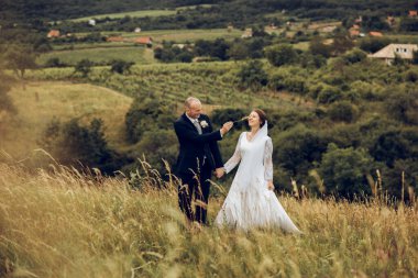 Gelin ve damat el ele tutuşur ve doğanın ortasında geleceğe bakar. Yeni evliler birlikte yürür. Düğün fotoğrafçılığı, ölüm bizi ayırana kadar.