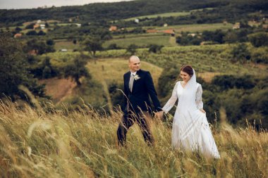 Gelin ve damat el ele tutuşur ve doğanın ortasında geleceğe bakar. Yeni evliler birlikte yürür. Düğün fotoğrafçılığı, ölüm bizi ayırana kadar.