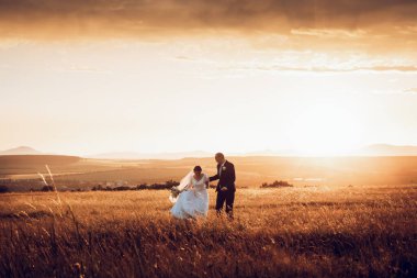 Gelin ve damat el ele tutuşur ve doğanın ortasında geleceğe bakar. Yeni evliler birlikte yürür. Düğün fotoğrafçılığı, ölüm bizi ayırana kadar.