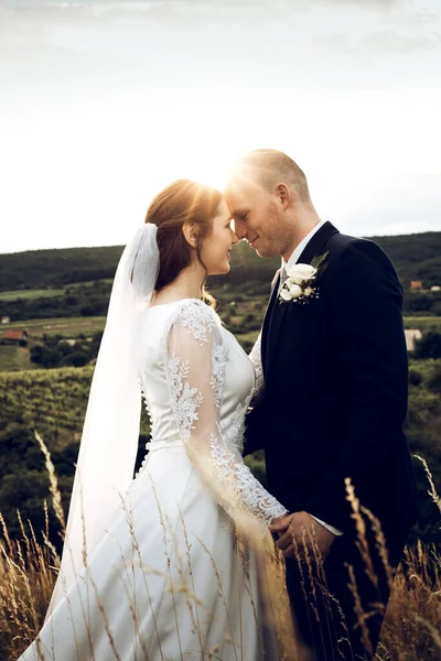 Gelin ve damat düğün çekimlerinde İsa 'nın heykeli önünde el ele tutuşuyorlar. Beyaz elbiseli güzel gelin ve şık damat.