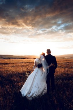 Gelin ve damat el ele tutuşur ve doğanın ortasında geleceğe bakar. Yeni evliler birlikte yürür. Düğün fotoğrafçılığı, ölüm bizi ayırana kadar.