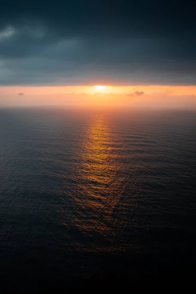 drone view of the ocean and the sun hidden in the clouds