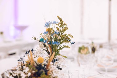 Düğün salonunun çekimleri çiçek ve ışıklarla süslenmiş masalar çatal bıçak takımı ve güzel dekorasyonlar, düğün günü.