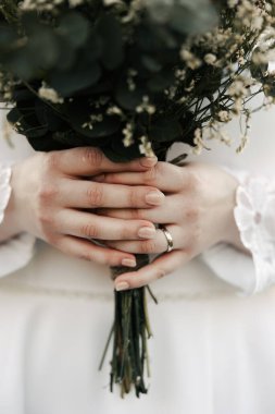 Beyaz elbiseli gelinin elinde güzel bir düğün buketi, canlı çiçekler, düğün günü