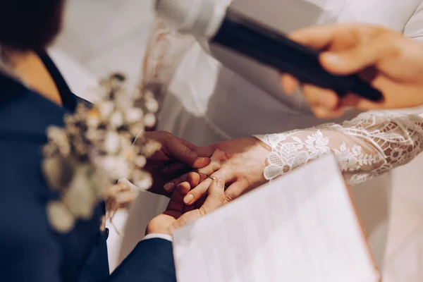 beautiful shot of the hands of two young people who promise love and fidelity in the church and exchange wedding rings, love, wedding, church