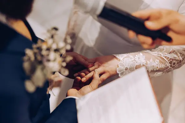 beautiful shot of the hands of two young people who promise love and fidelity in the church and exchange wedding rings, love, wedding, church