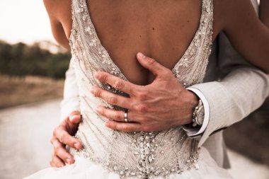  Yeni evliler birbirlerine sarılıyorlar, güzel beyaz elbiseli gelin, takım elbiseli damat, düğün töreninde, eller