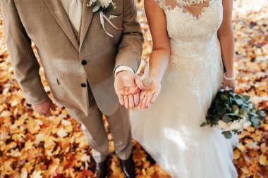 Beyaz elbisesi ve smokiniyle, birbirine kenetlenmiş iki kalbi bir araya getirirler, elleri birbirine dolanmış, sonsuza dek bağlarını simgeleyen yüzükleri tutarlar. Bir an için aşk bir söz ile mühürlendi