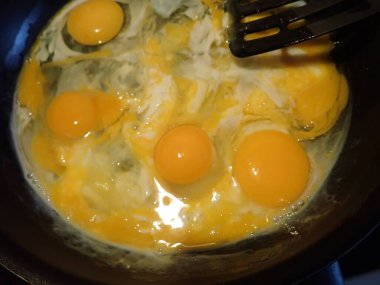 Mutfaktaki tavada çırpılmış yumurta hazırlıyorum.