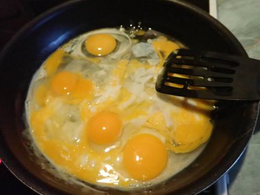 Mutfaktaki tavada çırpılmış yumurta hazırlıyorum.
