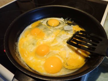 Mutfaktaki tavada çırpılmış yumurta hazırlıyorum.