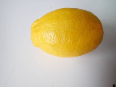 Beyaz bir masada tek bir limon.