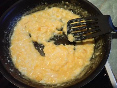 Mutfaktaki tavada çırpılmış yumurta hazırlıyorum.