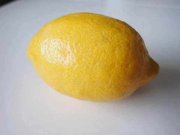 single whole lemon on a white table