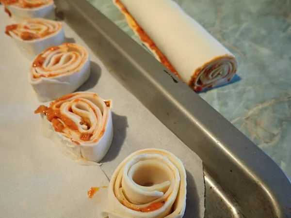 baking homemade pizza rolls from puff pastry in kitche