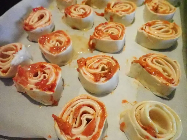 baking homemade pizza rolls from puff pastry in kitche