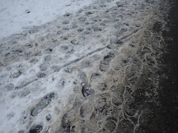frozen slippery snow on a sidewalk in a city park