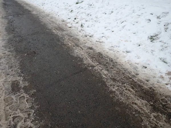 frozen slippery snow on a sidewalk in a city park