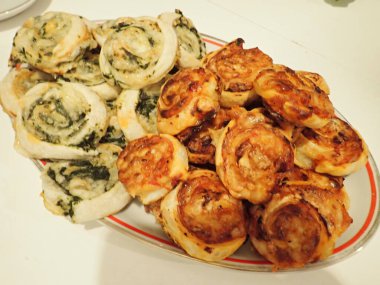 Ev yapımı pizza ve ıspanaklı börek bir partide servis edilir.