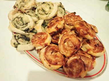 Ev yapımı pizza ve ıspanaklı börek bir partide servis edilir.