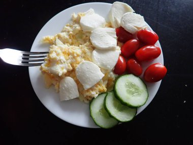 portion of scrambled eggs with vegetables on a table