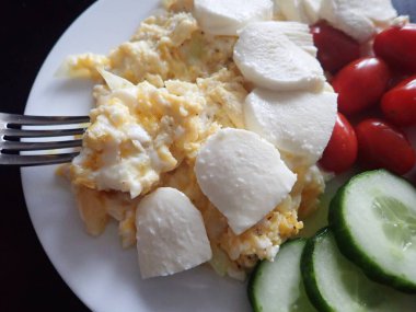 portion of scrambled eggs with vegetables on a table