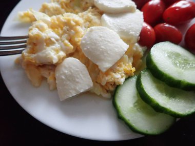 portion of scrambled eggs with vegetables on a table