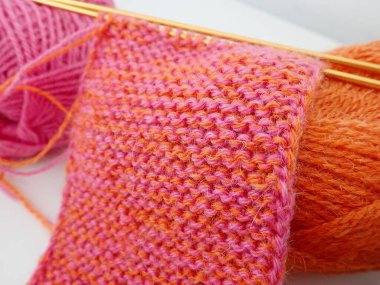 detail of knitting from an orange and pink wool