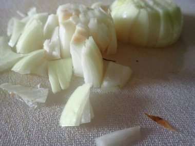 chopped onion on a cutting board in kitchen