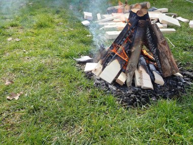 Yeşil bir çayırda bir kamp yangını başladı.