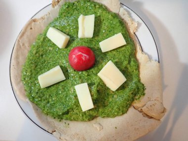 Tabakta yeşil pesto ve peynirli gözleme.