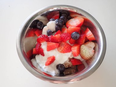 Kahvaltıda çilekli yoğurt ve yaban mersini ve badem.