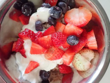 Kahvaltıda çilekli yoğurt ve yaban mersini ve badem.