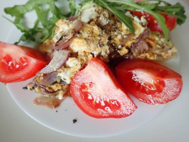 porsiyon omlet ve tabakta salata.