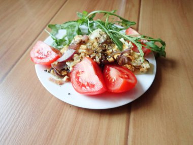 porsiyon omlet ve tabakta salata.