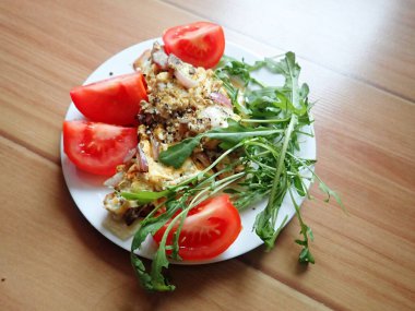 porsiyon omlet ve tabakta salata.