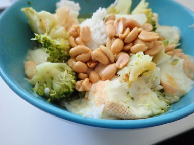 portion of broccoli risoto with peanuts in bowl clipart