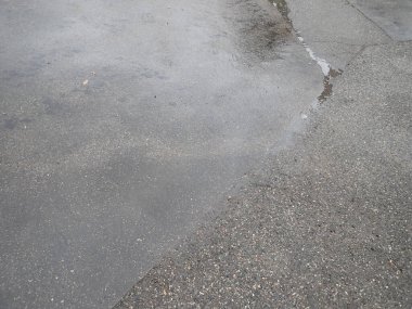 Islak asfalt yolda yağmurdan sonra kırılan çatlaklar