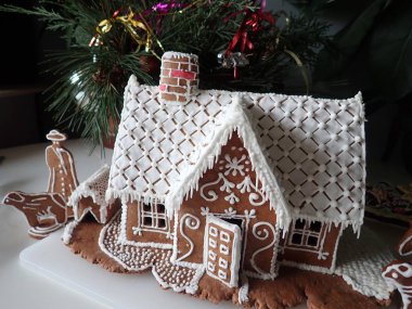 Ev yapımı geleneksel zencefilli kurabiye evi ve beyaz krema.