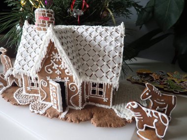 Ev yapımı geleneksel zencefilli kurabiye evi ve beyaz krema.