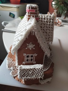 Ev yapımı geleneksel zencefilli kurabiye evi ve beyaz krema.