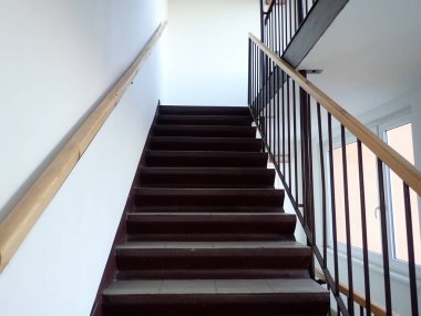 Açık gri kiremitleri olan ev merdivenleri yukarı çıkıyor.