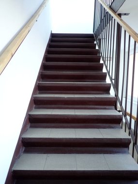 Açık gri kiremitleri olan ev merdivenleri yukarı çıkıyor.