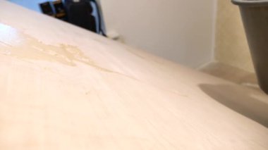 Repair concept. The craftsman applies glue to the wooden panel.